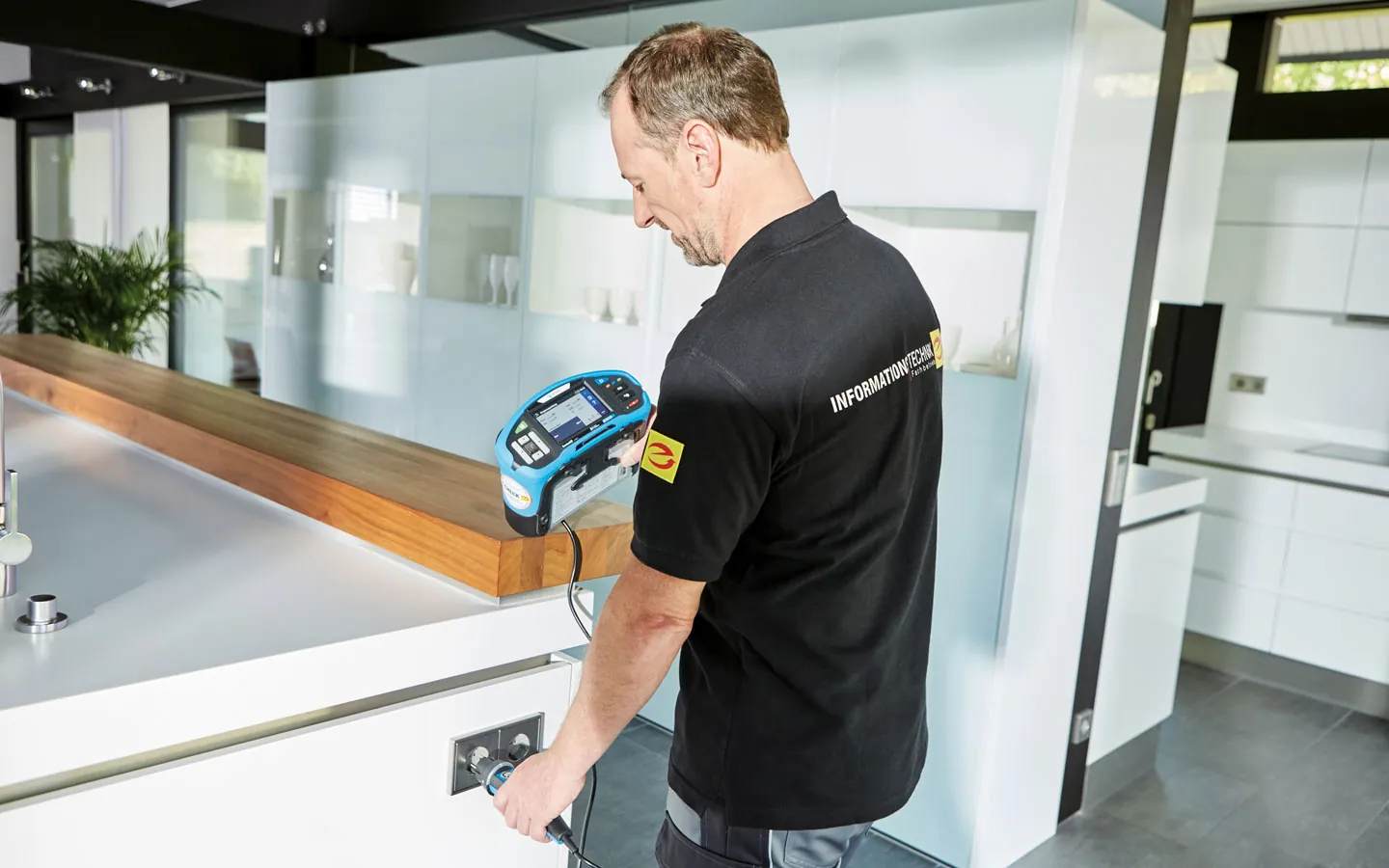 E-CHECK - Mitarbeiter prüft die Steckdosen in der Küche · Elektro-Diehm
