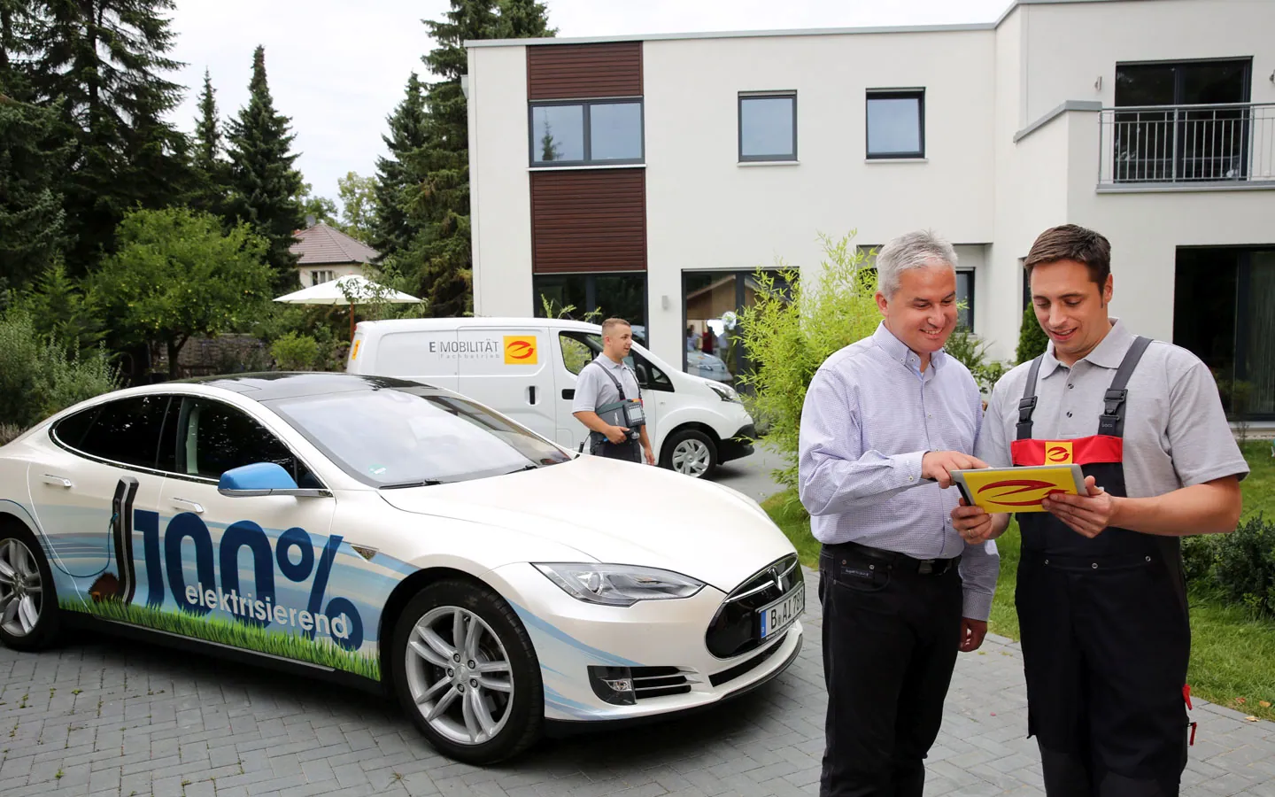 E-Mobilität - Mitarbeiter mit Kunden vor Elektrofahrzeugen 100% elektrisch · Elektro-Diehm